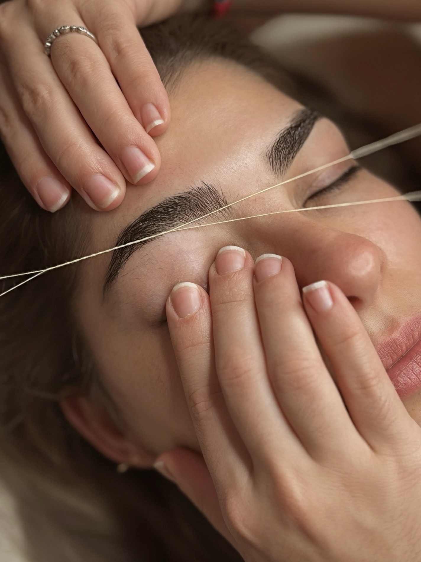 Eyebrow threading treatment in progress